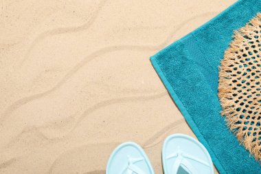 Plaj havlusu, terlik ve hasır şapkayla açık havada, düz yerde. Metin için boşluk