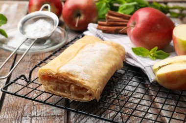 Lezzetli elmalı turta pudra şekeri, nane, meyve ve tarçınlı ahşap masa, yakın plan.