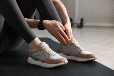 Spor sakatlığı. Spor salonunda bacak ağrısı çeken genç bir kadın, yakın plan.