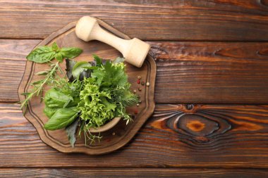 Kabuklu havan, farklı aromatik otlar ve ahşap masa üzerinde baharatlar, üst manzara. Metin için boşluk