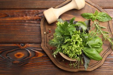 Kabuklu havan, farklı aromatik otlar ve ahşap masa üzerinde baharatlar, üst manzara. Metin için boşluk