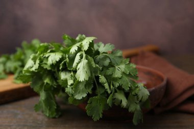 Tahta masada taze aromatik kişniş, yakın plan.