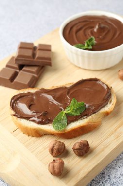 Lezzetli çikolata, tost, fındık ve nane. Gri desenli masa, yakın plan.