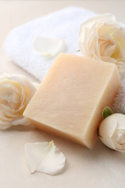 Aromatik sabun çubuğu ve güller ışık masasında.