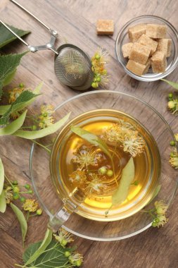 Taze ıhlamur çayı, şeker küpleri ve çiçekler ahşap masada, düz uzanmış