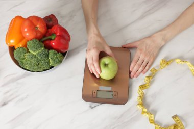 Kadın mutfak terazisinde ağırlıklı beyaz mermer masa, üst manzara