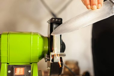 Bıçak keskinleştiren adam içeride, yakın plan.