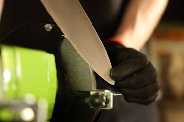 Bıçak keskinleştiren adam içeride, yakın plan.