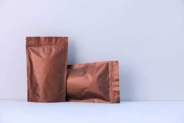 Açık gri arka planda iki fermuarlı stand-up kesesi. Tasarım için model