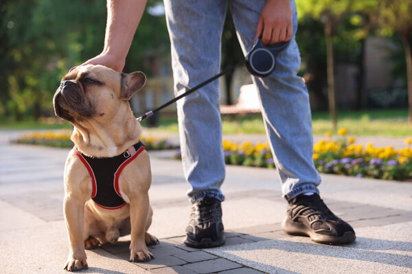 Man with his cute French bulldog in park, closeup