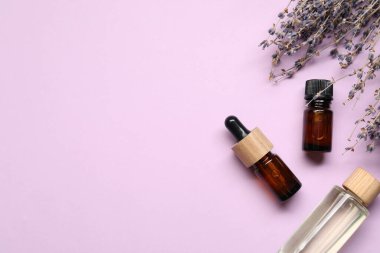 Doğal özlü yağ ve lavanta çiçekleri leylak arka planda, düz yerde. Metin için boşluk