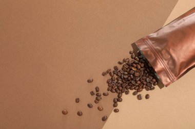 Fermuarlı stand-up kesesi ve kahve çekirdekleri arka planda, düz konum. Metin için boşluk