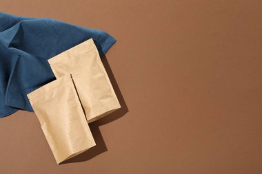 Kahverengi arka planda fermuar stand-up torbaları, düz yatış. Tasarım için model