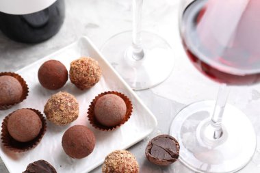 Kırmızı şarap bardakta ve yer mantarı şekerleri açık masada, yakın plan.