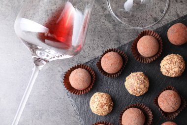 Lezzetli yer mantarı bonbonları ve gri desenli masada arta kalan kırmızı şarap.