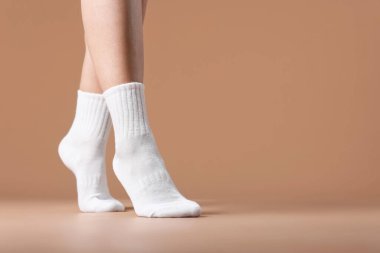 Bej arka planda beyaz çoraplı kadın, yakın plan. Metin için boşluk