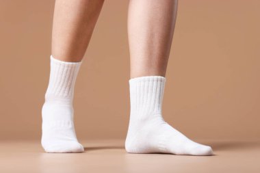 Bej arka planda beyaz çoraplı kadın, yakın plan.