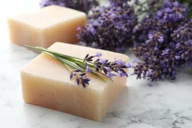 Sabun çubukları ve lavanta çiçekleri beyaz mermer masada, yakın plan.