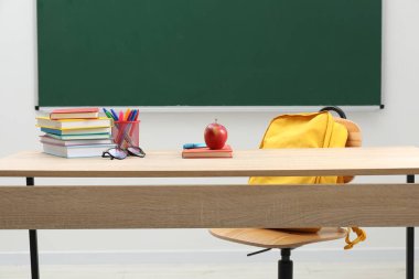 Farklı okul kırtasiyesi, gözlük ve kırmızı elma.