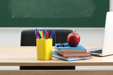 Farklı okul kırtasiyesi, dizüstü bilgisayar ve kırmızı elma.