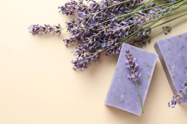 Aromatik sabun barları ve bej arka planda lavanta çiçekleri. Metin için boşluk