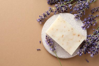 Aromatik sabun ve bej arka planda lavanta çiçekleri. Metin için boşluk