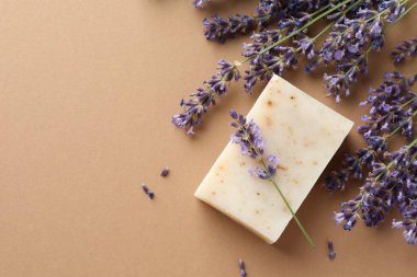 Aromatik sabun ve bej arka planda lavanta çiçekleri. Metin için boşluk