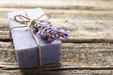 Aromatik sabun barı ve lavanta çiçekleri ahşap masada, yakın plan. Metin için boşluk