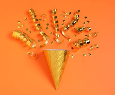 Parlak parti flamaları, turuncu arka planda konfeti ve koni.