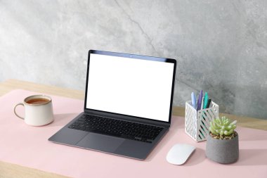 İçerideki beyaz masada dizüstü bilgisayarı ve pembe faresi olan şık bir iş yeri. Metin için boşluk