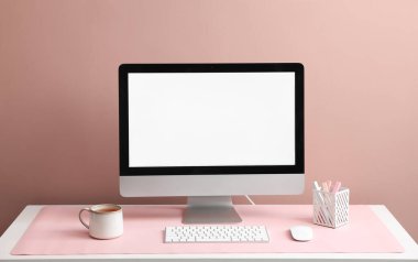 Beyaz masa üzerinde bilgisayar ve pembe fare reklamı olan şık bir iş yeri. Metin için boşluk