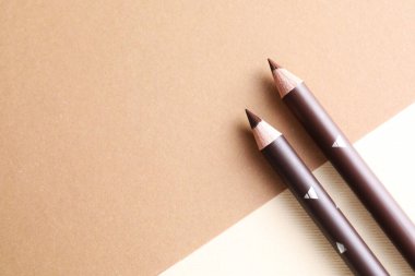 Bej arka planda farklı kaş kalemleri, üst manzara. Metin için boşluk
