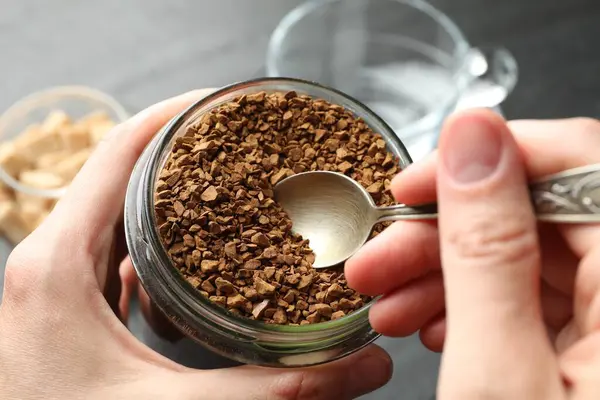 Masada kavanozdan hazır kahve alan kadın, yakın plan.