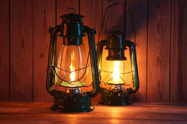 Ahşap masada iki eski gaz lambası.