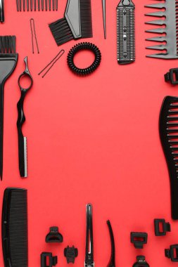 Kırmızı arka planda farklı kuaför aletleri çerçevesi, düz. Metin için boşluk