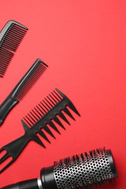Kırmızı arka planda farklı kuaför aletleri var. Metin için boşluk