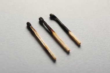 Gri arkaplanda yanmış kibritler, yakın plan görünümü