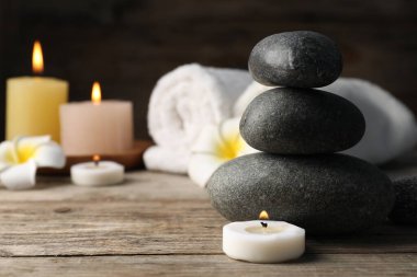 Tahta masanın üzerinde spa taşları olan kompozisyon, yakın plan.