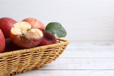 Şımarık elma ve güzel elmalar beyaz ahşap masada, yakın plan. Metin için boşluk