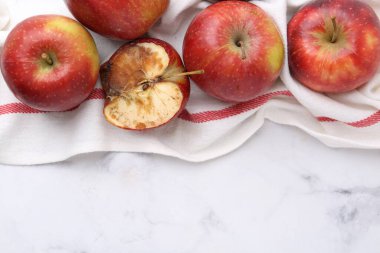 Şımarık elma ve iyi elmalar beyaz masada, düz yerde. Metin için boşluk