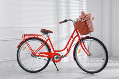 Beyaz duvarın yanında bir sepet güzel çiçekli bisiklet.