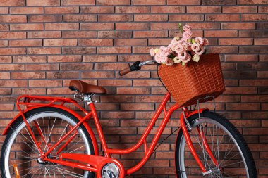 Evin içinde tuğla duvarın yanında bir sepet güzel çiçekli bisiklet.