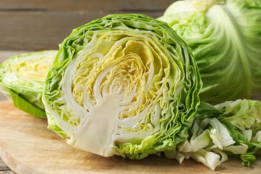 Ahşap masada kesim ve tüm lahanalar, yakın plan.