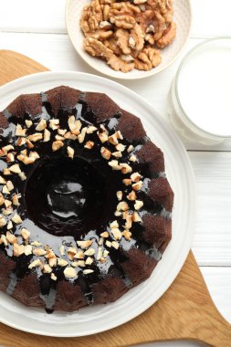 Fındıklı çikolatalı kek ve beyaz ahşap masada bir bardak süt.