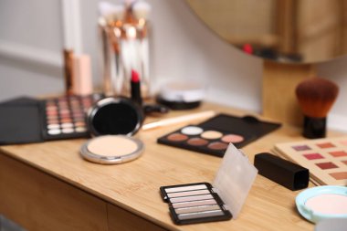 Kapalı alanda ahşap gösteriş üzerine farklı makyaj ürünleri.