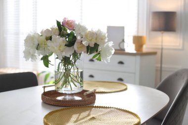 Yemek odasında bir vazo çiçekli güzel bir masa.