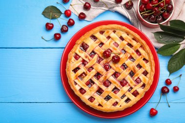 Lezzetli kirazlı turta ve böğürtlen açık mavi ahşap masa, düz uzanmış