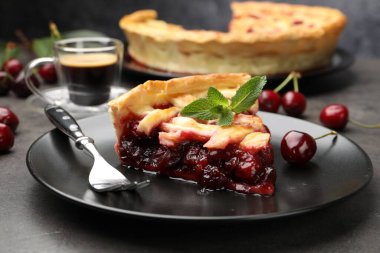 Gri masadaki lezzetli vişneli turta ve böğürtlen, yakın plan.