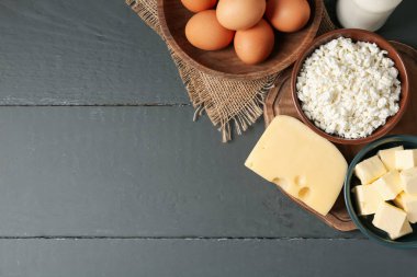 Gri ahşap masa üzerinde farklı süt ürünleri ve yumurtalar, düz yatak. Metin için boşluk