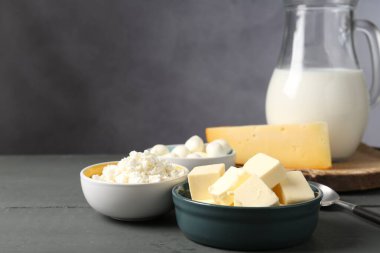 Gri ahşap masada farklı süt ürünleri, yakın plan.